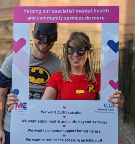  two people dressed as batman and robin fundraise for charity